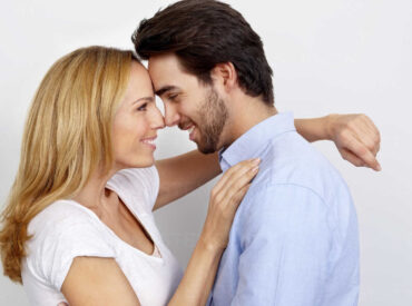 Portrait of loving couple in front of white background